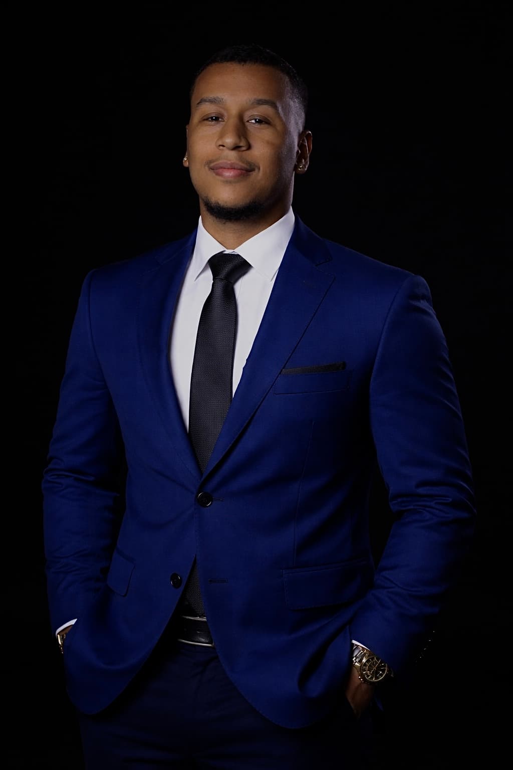 Advogado Caio Santana em traje azul sobre fundo escuro
