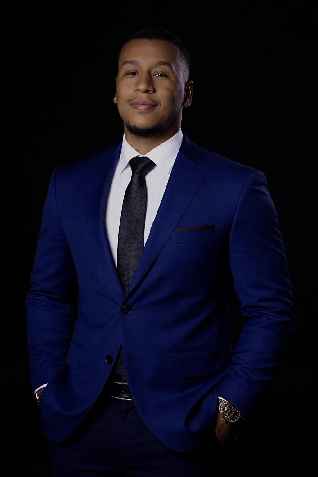Advogado Caio Santana em traje azul sobre fundo escuro